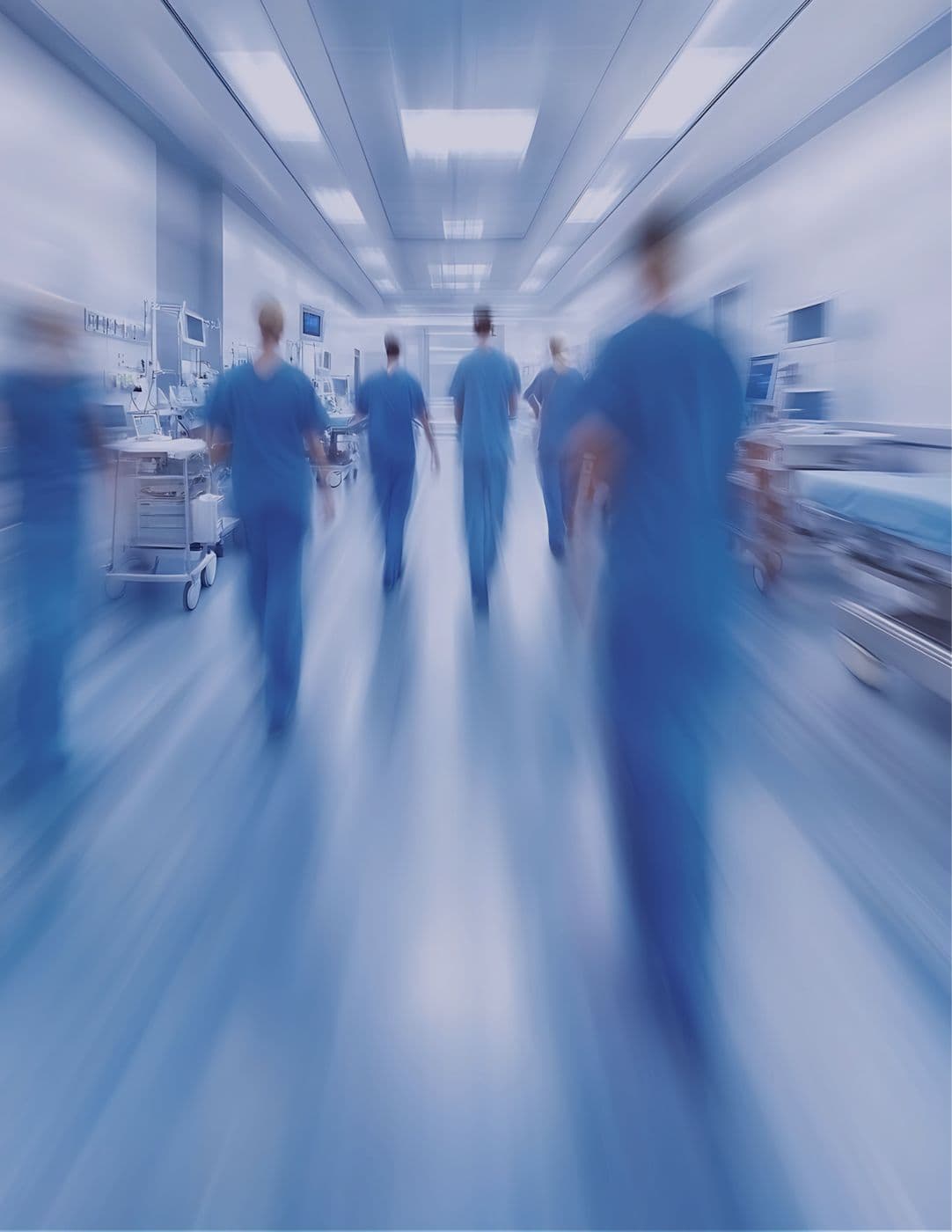 Clinicians in scrubs walking down a hospital corridor